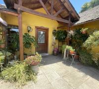 Entrada principal, puerta de madera y pequeña terraza; con ante jardín