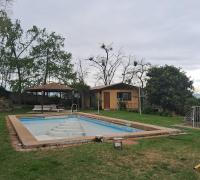 piscina y al fondo quincho cerrado con comedor y baños