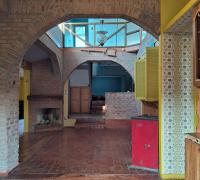 vista desde la entrada poniente hacia el hall y living comedor, estuda a pellets, lindas lámparas y arco