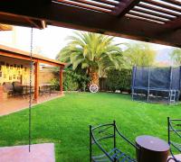 Jardín formado con árboles grandes y riego automático 