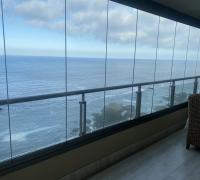 Terraza con vista al océano equipada con set de sillones de ratán y mesa