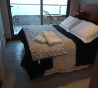 Dormitorio con cama de dos plazas, closet, ropa de cama con salida al balcon