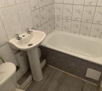  “Baño completo, equipado con tina y lavamanos pedestal, con cerámicos en muros y un espacio funcional de uso diario.”