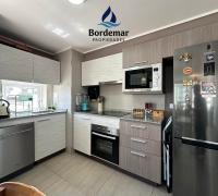 Moderna cocina integrada de gran amplitud, totalmente equipada con encimera, horno empotrado y campana de alta eficiencia