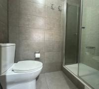 Baño principal con diseño funcional: Lavamanos independiente del área de sanitarios. Zona húmeda equipada con shower door de cristal templado, grifería moderna y revestimientos en porcelanato de alta calidad.