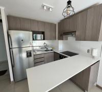 Cocina funcional y equipada con acabados contemporáneos e integración fluida al living