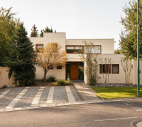 Fachada de casa de dos pisos con antejardín, acceso peatonal y estacionamientos exteriores.