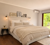 Dormitorio principal con cama matrimonial y gran ventana.