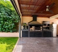 Quincho techado con parrilla, campana, lavaplatos, refrigerador y salida directa al jardín.