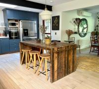 Cocina abierta con isla central, muebles azules e integración al comedor.