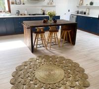 Cocina con isla central, cubierta de madera, campana y abundante luz natural.