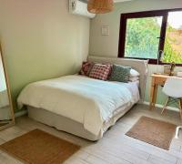 Dormitorio 3 con escritorio, amplio ventanal, vista despejada y aire acondicionado.