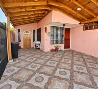 Vista del patio techado, con piso de baldosas y acceso a la vivienda.