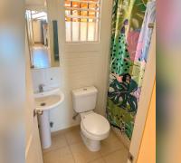 Vista de otro baño de la casa, con lavamanos, inodoro y ventana.