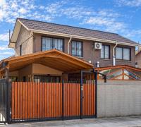 Fachada de casa de dos niveles en Rancagua, con cierre de madera y acceso techado.