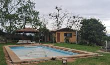 piscina y al fondo quincho cerrado con comedor y baños