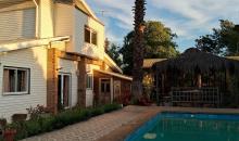 Vista de norte a sur desde la piscina a la casa y quincho al atardecer