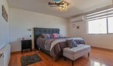 Dormitorio principal con vista al mar, amplio closet integrado y baño privado de finas terminaciones.aciones