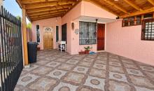 Vista del patio techado, con piso de baldosas y acceso a la vivienda.