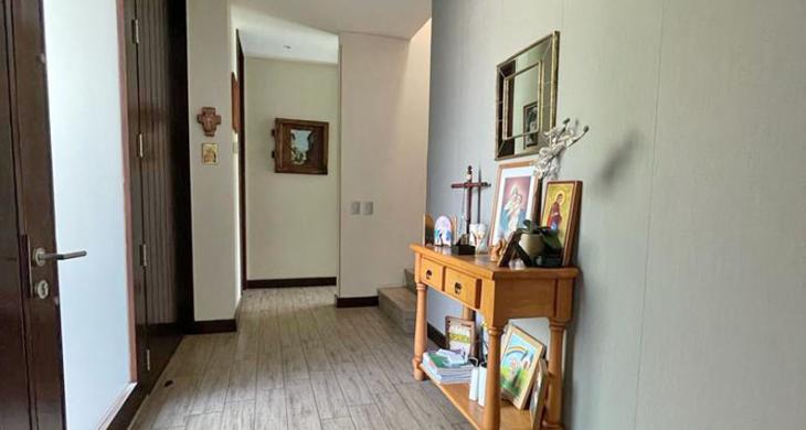 Hall de acceso que comunica con baño de visita, dormitorio en suite, escalera segundo piso y living comedor