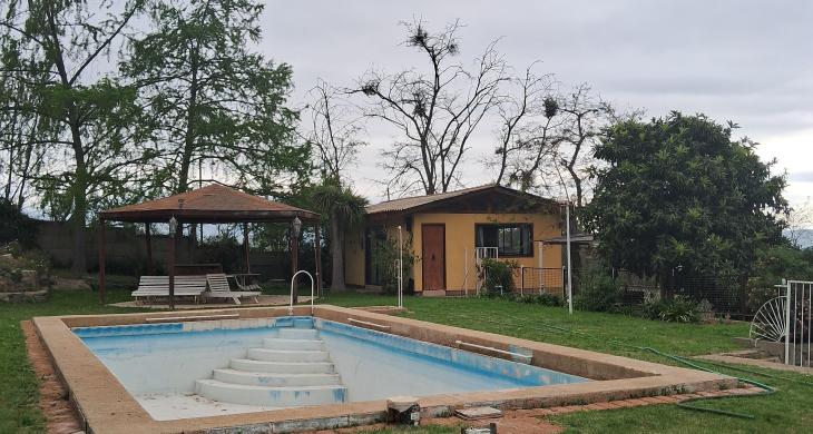 piscina y al fondo quincho cerrado con comedor y baños