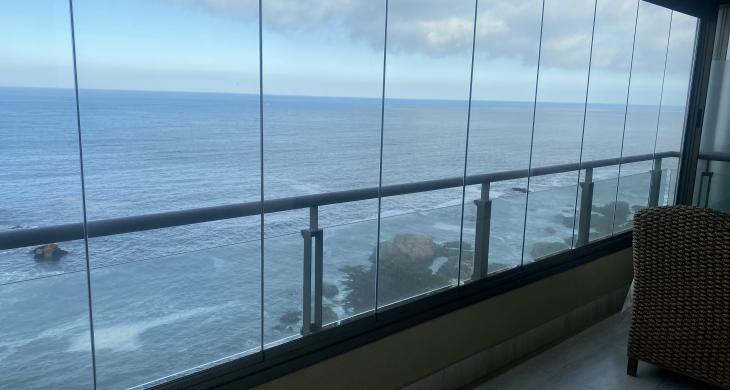 Terraza con vista al océano equipada con set de sillones de ratán y mesa