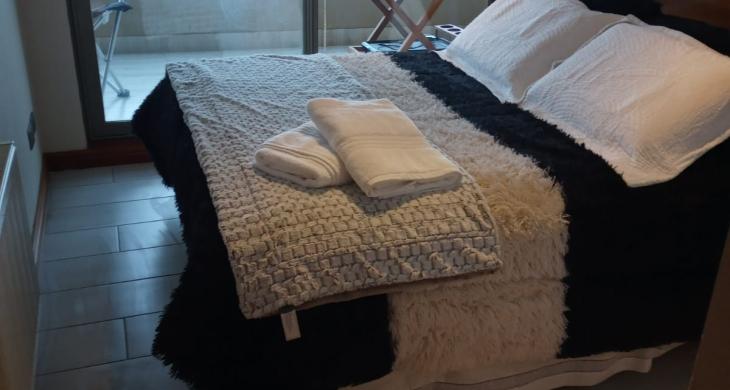 Dormitorio con cama de dos plazas, closet, ropa de cama con salida al balcon