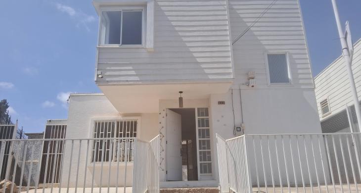 Frente, se aprecia reja de antejardín con dos entradas laterales al patio