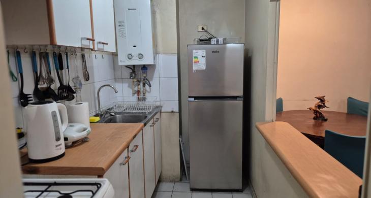 Funcional cocina semi-integrada con mesón central, ideal para disfrutar comodamente