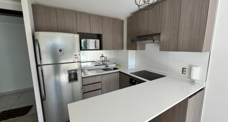 Cocina funcional y equipada con acabados contemporáneos e integración fluida al living