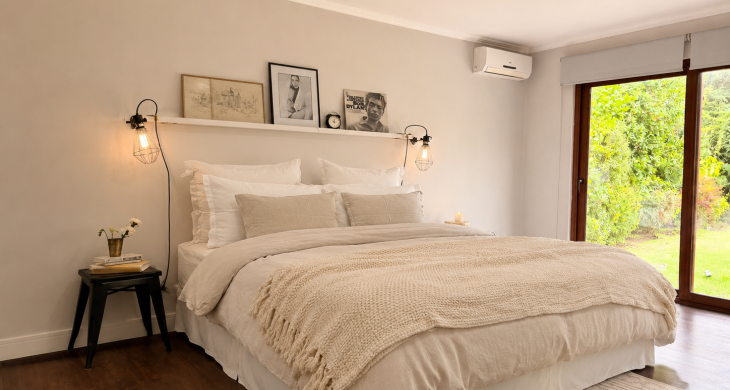 Dormitorio principal con cama matrimonial y gran ventana.