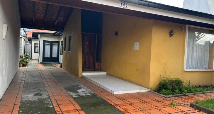 VISTA FRONTAL DE CASA QUE DESTACA ESTACIONAMIENTO PARA 3 VEHICULOS