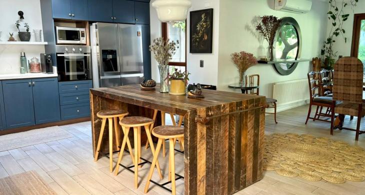 Cocina abierta con isla central, muebles azules e integración al comedor.